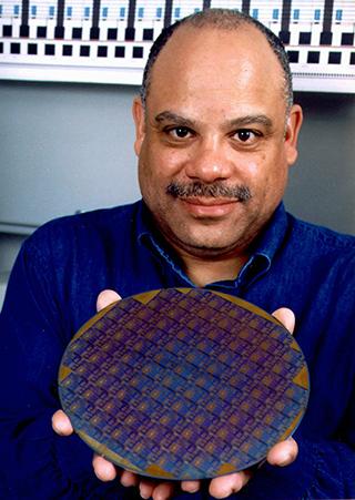 Image of Mark Dean holding the first one-gigahertz computer processing chip